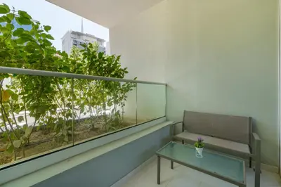 a balcony with a bench and a table and a window at White Sage- Damac Vera Residences 417 in Dubai