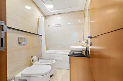 a bathroom with a toilet and a sink and a tub at Great 2BR APT Ocean Heights in Dubai