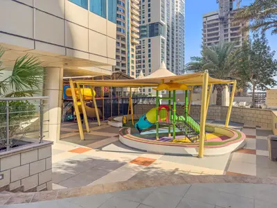a playground with a slide in a city at Great 2BR APT Ocean Heights in Dubai