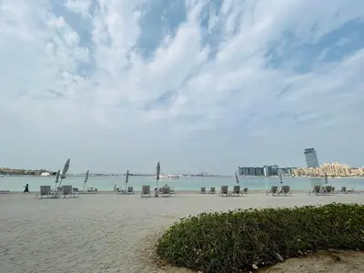a beach with tables and chairs and the ocean at StoneTree - Luxurious with Private Beach Access in Dubai