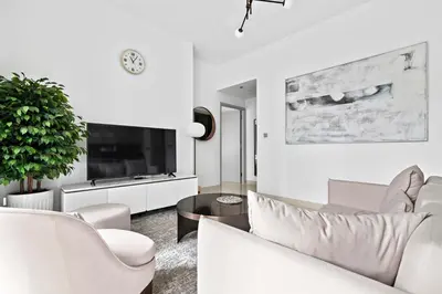 a living room with white furniture and a tv at StoneTree - Luxurious with Private Beach Access in Dubai