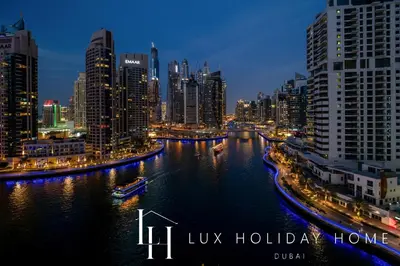 a view of a city at night with a river at LUX The Marina View Suite 1 in Dubai