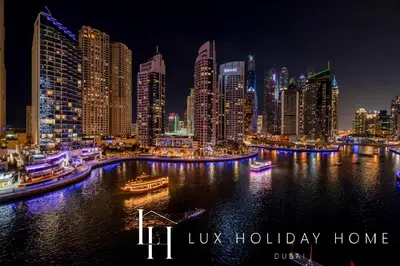 a city skyline at night with boats in the water at LUX The Marina View Suite 1 in Dubai