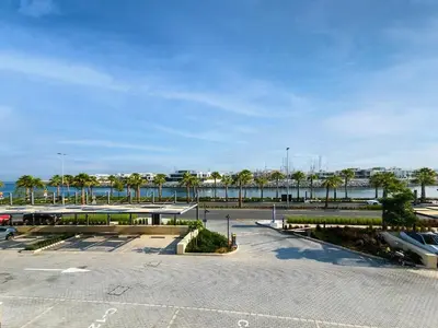 a parking lot with a view of the water at Beautiful 1 bedroom in Port De La Mer in Dubai