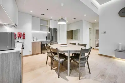 a kitchen and dining room with a table and chairs at Beautiful 1 bedroom in Port De La Mer in Dubai