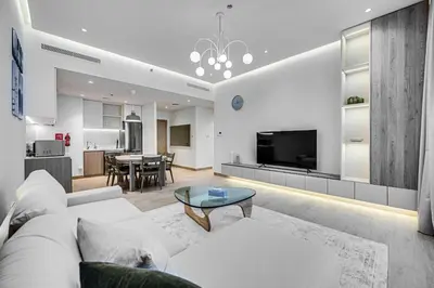 a living room with a white couch and a table at Beautiful 1 bedroom in Port De La Mer in Dubai