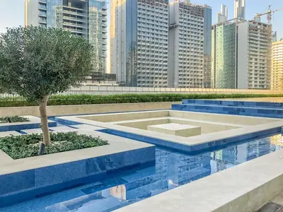 a fountain with a tree in the middle of a city at GuestReady - Vibrant Retreat in Dubai's Heart in Dubai
