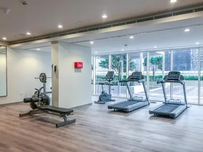 a gym with several treadmills and ellipticals in a room at GuestReady - Vibrant Retreat in Dubai's Heart in Dubai