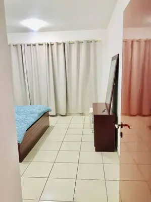 a room with a bed and a television in it at Amiqa Homes DIP 1 in Sharjah