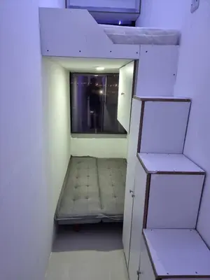 a small room with a bed and a mirror at Amiqa Homes DIP 1 in Sharjah