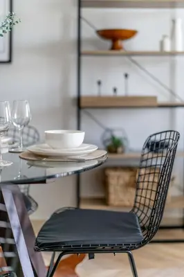 a black chair sitting next to a table with a plate at GuestReady Holiday Homes - Urban Elegance in JLT in Dubai