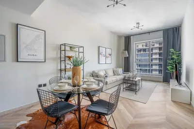 a living room with a table and chairs and a couch at GuestReady Holiday Homes - Urban Elegance in JLT in Dubai