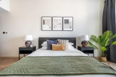 a bedroom with a large bed with two night stands at GuestReady Holiday Homes - Urban Elegance in JLT in Dubai
