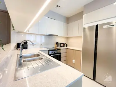 a kitchen with a sink and a stainless steel refrigerator at Luxury Burj Royale Apt Balcony Burj Khalifa View in Dubai