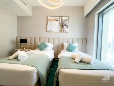two twin beds in a room with a window at Luxury Burj Royale Apt Balcony Burj Khalifa View in Dubai