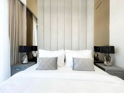 a bedroom with a large white bed with two lamps at Luxury Burj Royale Apt Balcony Burj Khalifa View in Dubai
