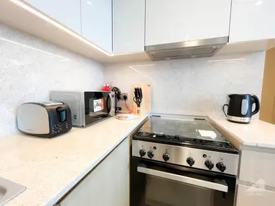 a kitchen with a stove and a microwave at Burj Royale Luxury 1B Balcony & City View Downtown in Dubai