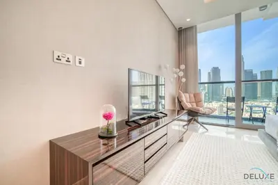 a living room with a television and a couch at Plush Studio at The Sterling East House Business Bay by Deluxe Holiday Homes in Dubai