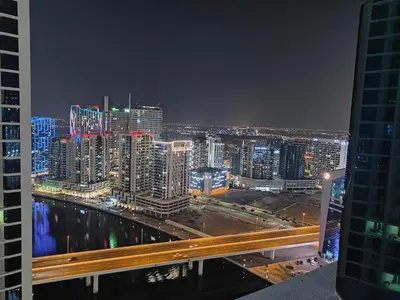 a view of a city skyline at night at LeModCasa - Luxury smart Studio with Canal View Business Bay in Dubai