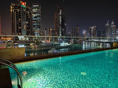 a swimming pool with a view of a city at night at LeModCasa - Luxury smart Studio with Canal View Business Bay in Dubai