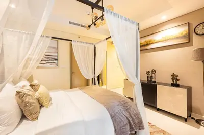 a bedroom with a white bed with curtains at Stylish 2BR at Paramount Hotel Midtown in Dubai