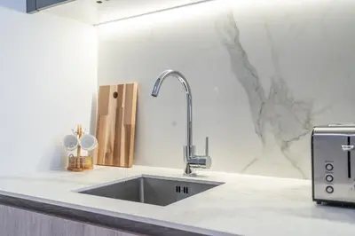 a kitchen with a stainless steel sink in a counter at Fashionable loft with catamaran net in JVC in Dubai