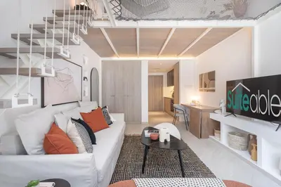 a living room with a white couch and a table at Fashionable loft with catamaran net in JVC in Dubai
