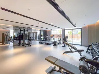 a gym with several treadmills and cardio machines at Fashionable loft with catamaran net in JVC in Dubai