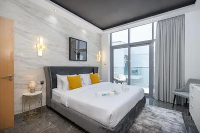 a bedroom with a large bed with yellow pillows at Modern Comfort in a Spacious Apartment - Suiteable in Dubai