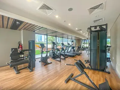 a gym with several treadmills and exercise machines at Serenity in Style in Zada Residence by Suiteable in Dubai