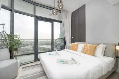 a bedroom with a large white bed with a large window at Serenity in Style in Zada Residence by Suiteable in Dubai