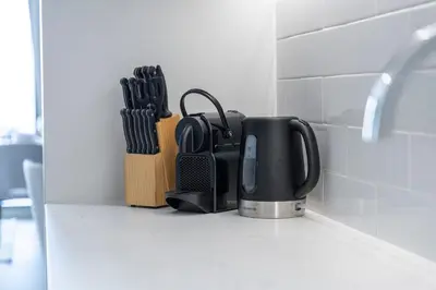 a coffeemaker sitting on a kitchen counter with knives at Dive into Luxury at LIV Residence - Suiteable in Dubai