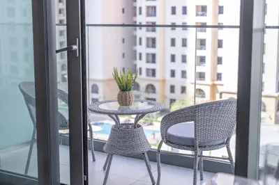 a table and chairs on a balcony with a window at Dive into Luxury at LIV Residence - Suiteable in Dubai
