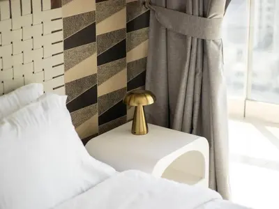a bed with a gold lamp on a table next to a window at Downtown Chic Easy walk to Dubai Mall & Fountain in Dubai