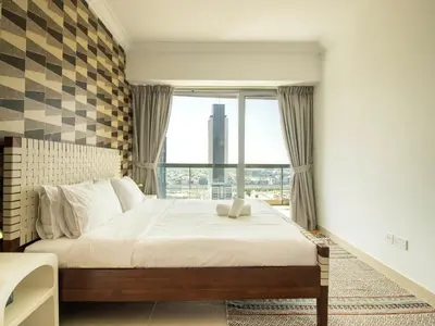 a bedroom with a bed and a large window at Downtown Chic Easy walk to Dubai Mall & Fountain in Dubai