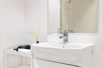 a white bathroom with a sink and a mirror at Tranquil Dubai Marina Studio by JBR Beach, Marina Mall, Metro in Dubai