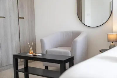 a living room with a chair and a table at New Listing - TOP Amenities in JVC in Dubai