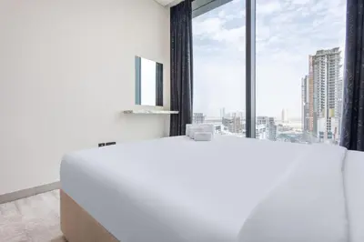 a white tub in a room with a large window at STAY BY LATINEM Luxury 2BR Holiday Home W1504 near Burj Khalifa in Dubai