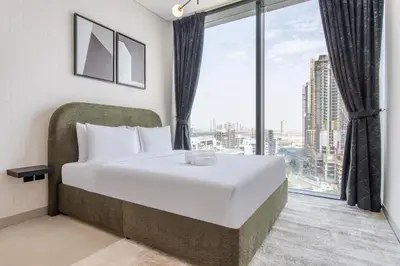 a bedroom with a large bed and a large window at STAY BY LATINEM Luxury 2BR Holiday Home W1504 near Burj Khalifa in Dubai