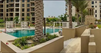 a swimming pool with a palm tree in a resort at Nasma Luxury Stays - Fabulous Apartment With Balcony Near MJL's Souk in Dubai