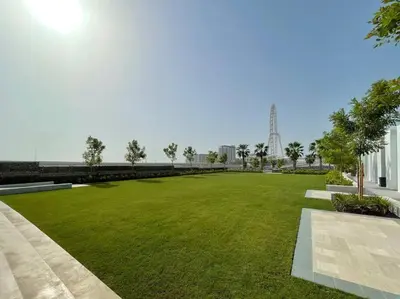 a park with green grass and a bridge in the background at 1BR •The Address Beach Residence - High floor in Dubai