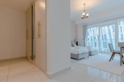 a white bedroom with a bed and a dining room at Fantastic View l Great Amenities l Superb Location in Dubai