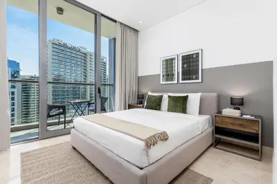 a bedroom with a large white bed and a large window at Maison Privee - Classy Urban Retreat with Amazing Dubai Canal Views in Dubai