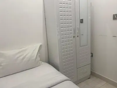 a white bedroom with a bed and a closet at Coliving Sharing Hostel ll in Dubai