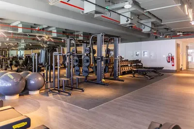 a gym with rows of exercise equipment on the floor at Maison Privee - Exquisite Duplex with Private Patio & Loft Living in Dubai