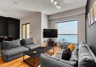 a living room with a couch and a flat screen tv at First Class Apartments in Heart of JBR, Steps to the Beach - 121 Living in Dubai