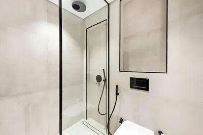 a shower with a glass door in a bathroom at Stylish Studio with Gym and Pool in Dubai