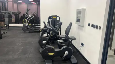 a gym with several tread machines in a row at Stylish Studio with Gym and Pool in Dubai