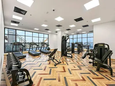 a gym with treadmills and cardio equipment in a building at Stylish Studio with Gym and Pool in Dubai