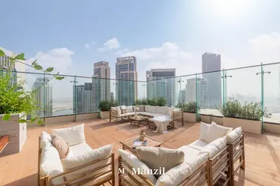 a balcony with couches and a view of the city at Manzil - Luxury 4BR Penthouse with Harbour View & Private Terrace at Dubai Creek Harbour in Dubai